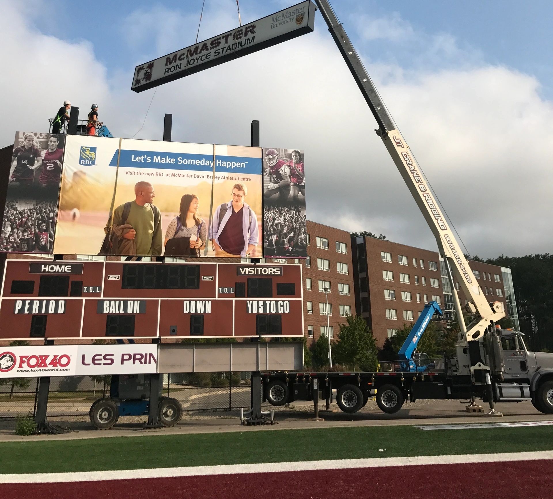 Sign being hoisted in Hamilton, Ontario by boom truck rental for steel erecting company