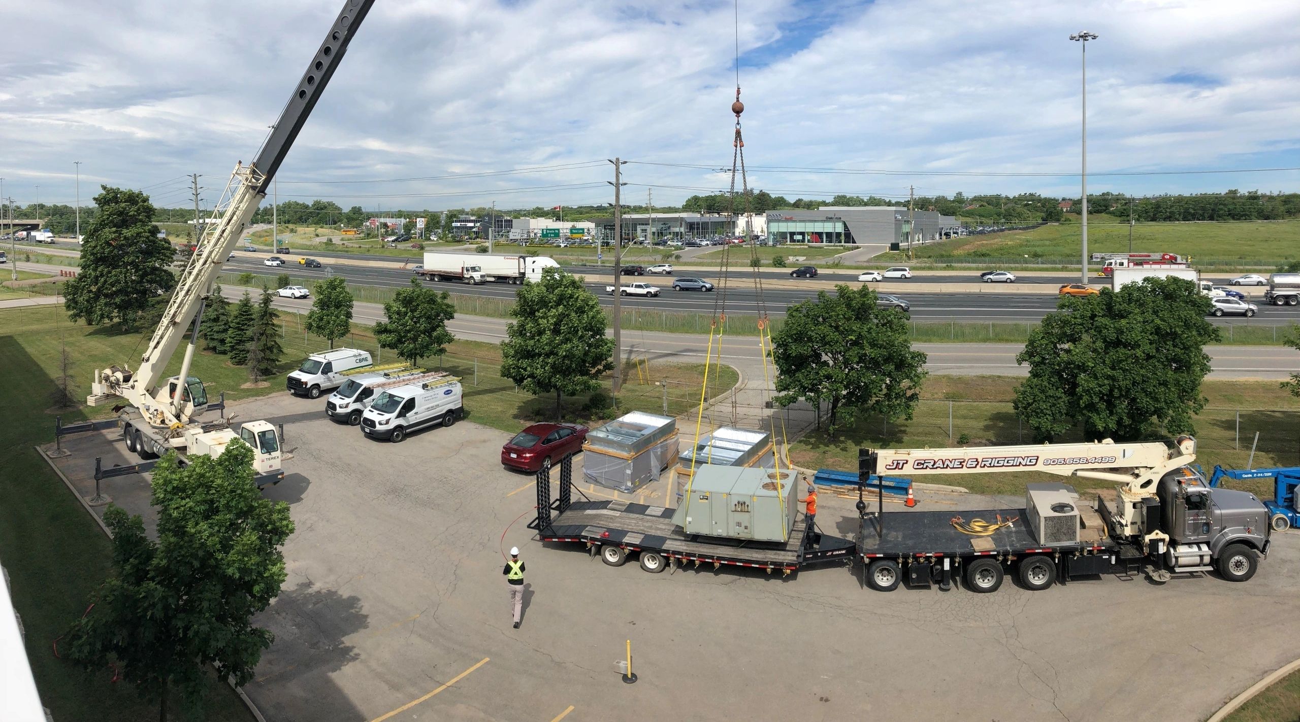 Boom truck and mobile crane rental hoisting HVAC units to roof in Mississauga, Ontario